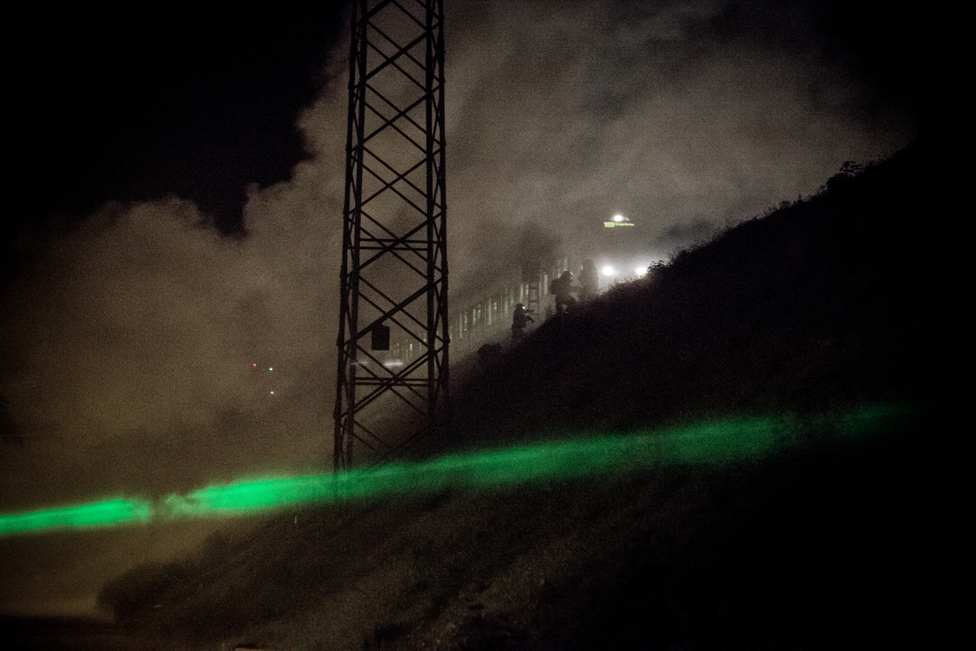 Die Polizei besteigt den angehaltenen Zug. Ob wegen Tränengas oder der Gefahr von Demonstranten auf der Schiene ist unklar.