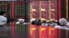 Gebannte Blicke auf die Kurstafel einer Börse in Shanghai: Auch am Dienstag stiegen die Aktien mit Verlusten in den Handel.