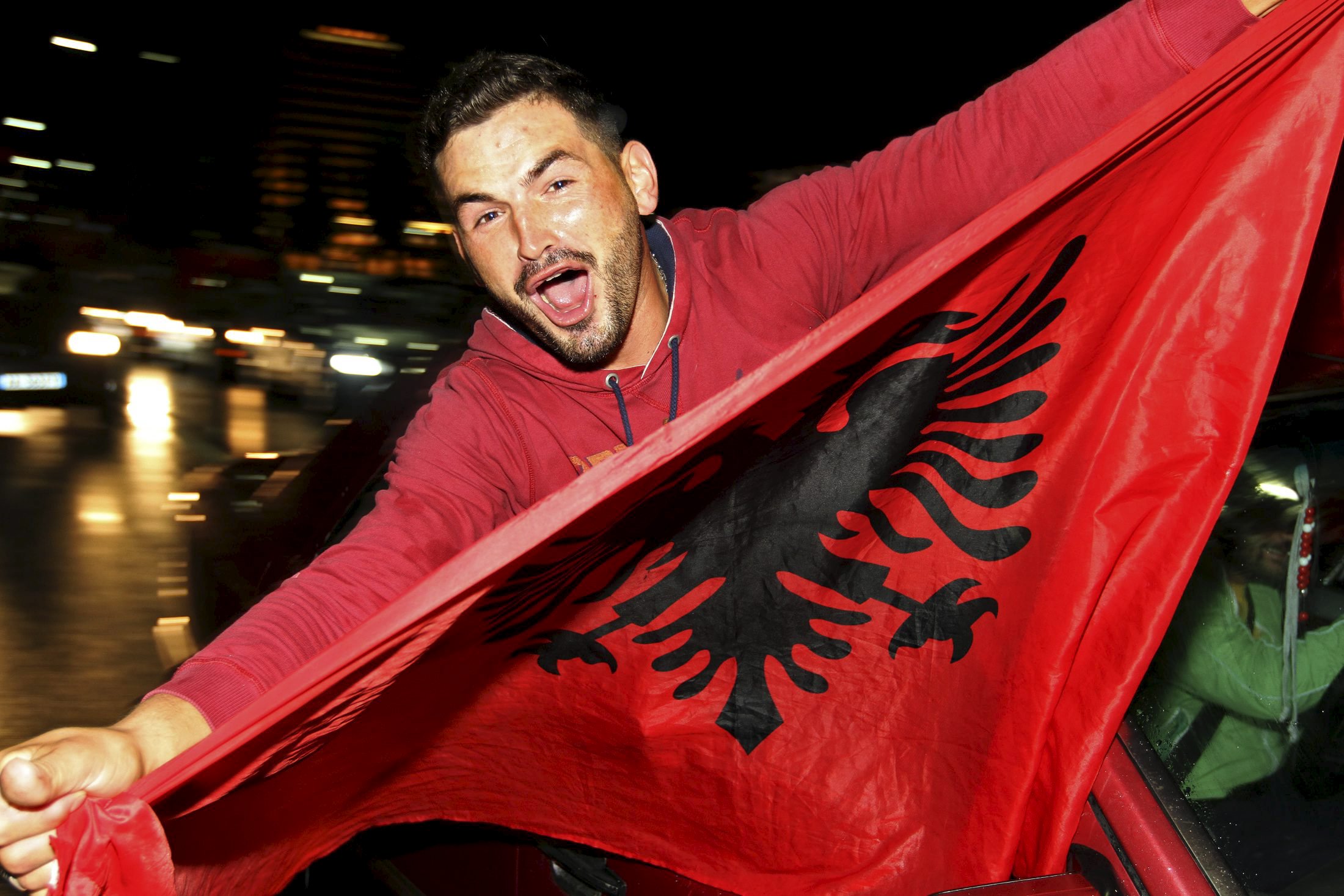 An Albanian soccer fan celebrates after Albania beat Armenia in their Euro 2016 Group I qualifying soccer match, in Tirana, Albania October 11, 2015. Albania qualified for Euro 2016, their first ever major tournament, when a 3-0 away win over Armenia clinched second place in Group I above Denmark on Sunday sparking wild celebrations across the country. REUTERS/Arben Celi