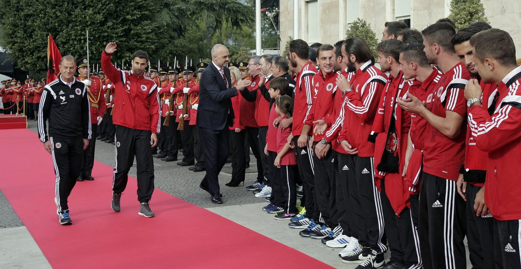 epa04975228 Albanian National soccer team is received by Albanian Prime Minister Edi Rama (C) accompanied by Albanian Head Coach Giovanni De Biasi (L) and Captain lorik Cana (C) in front of Government building in Tirana, Albania, 12 October 2015. Thousands of Albanians turned out in the capital Tirana to welcome the national football team after it secured the country's first-ever place at a major finals. Albania the previous day secured second spot in Euro 2016 qualifying Group I with a 3-0 win away to Armenia. EPA/FLORION GOGA