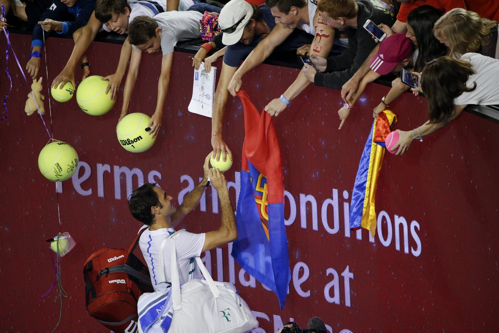 epa05117710 Roger Federer of Switzerland signs autographs for fans after winning a third round match against Grigor Dimitrov of Bulgaria at the Australian Open Grand Slam tennis tournament in Melbourne, Australia, 22 January 2016. EPA/LYNN BO BO