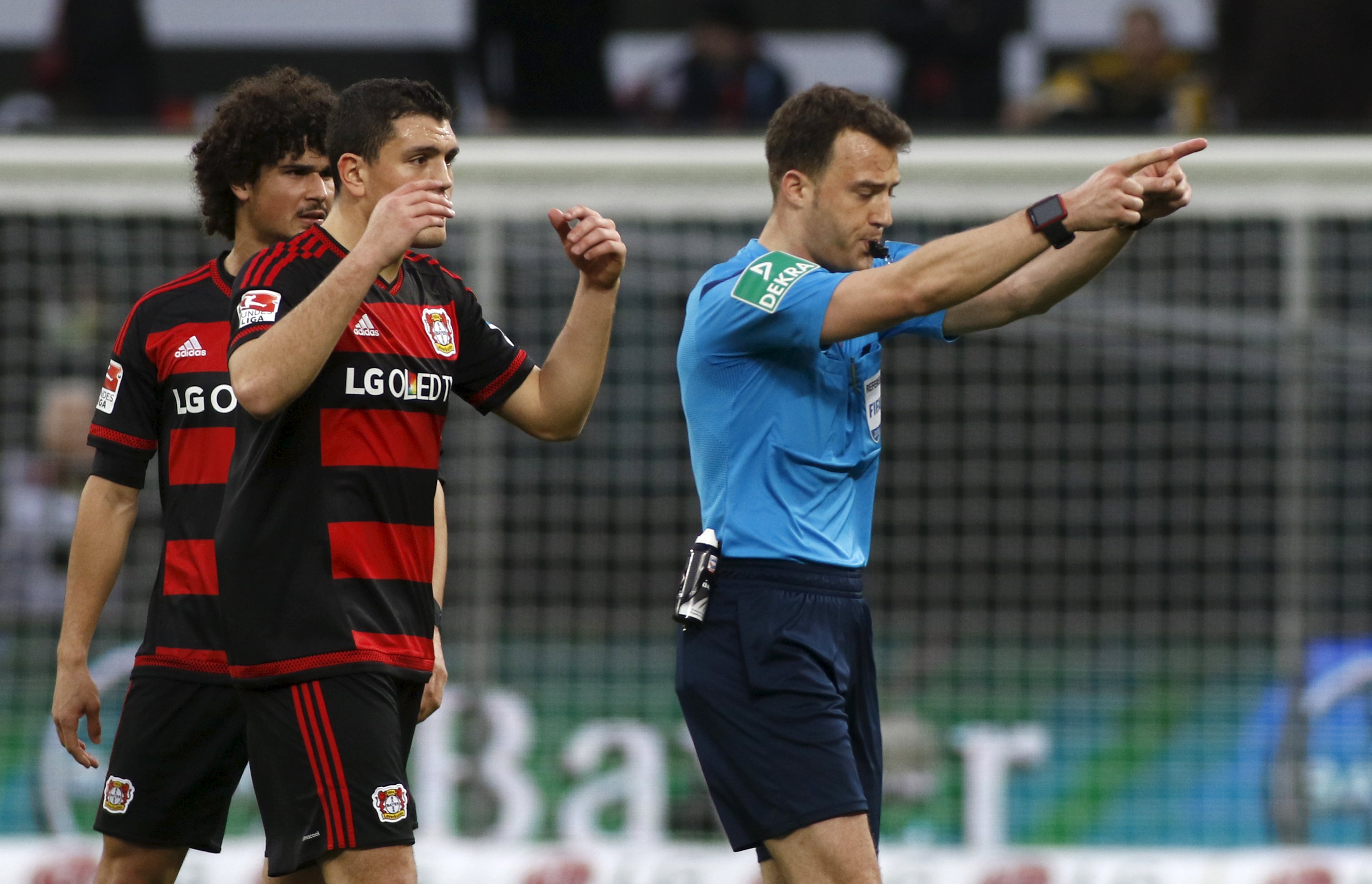 Football Soccer -- Bayer Leverkusen v Borussia Dortmund - German Bundesliga - BayArena , Leverkusen, 21/02/16 Referee Felix Zwayer and Leverkusen's Kyriakos Papadopoulos and Ramalho (L) react. REUTERS/Ina Fassbender DFL RULES TO LIMIT THE ONLINE USAGE DURING MATCH TIME TO 15 PICTURES PER GAME. IMAGE SEQUENCES TO SIMULATE VIDEO IS NOT ALLOWED AT ANY TIME. FOR FURTHER QUERIES PLEASE CONTACT DFL DIRECTLY AT + 49 69 650050