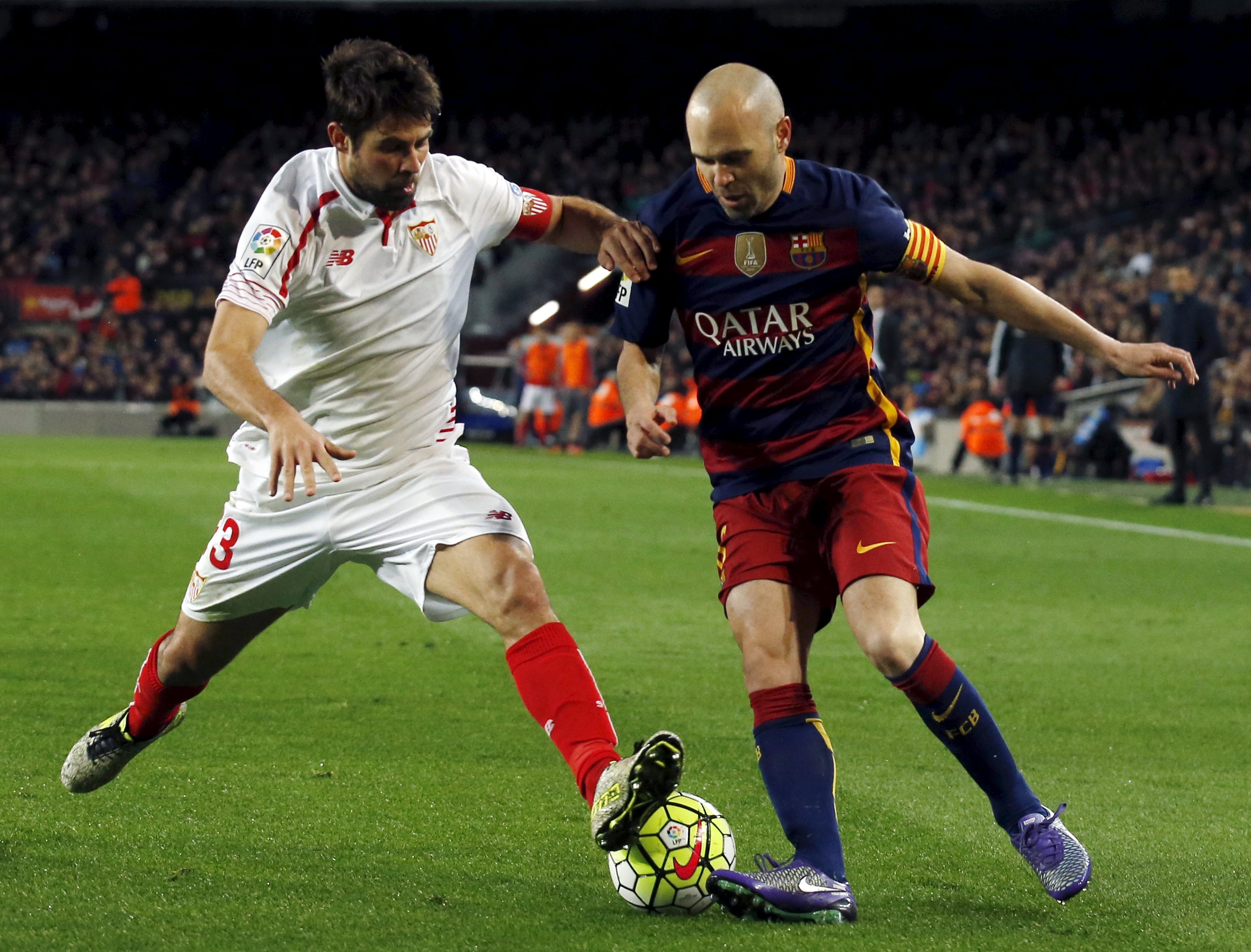 Football Soccer - Barcelona v Sevilla - Spanish Liga BBVA - Camp Nou stadium, Barcelona - 28/2/16Barcelona's Andres Iniesta fights for the ball against Sevilla's Coke. REUTERS/Albert Gea