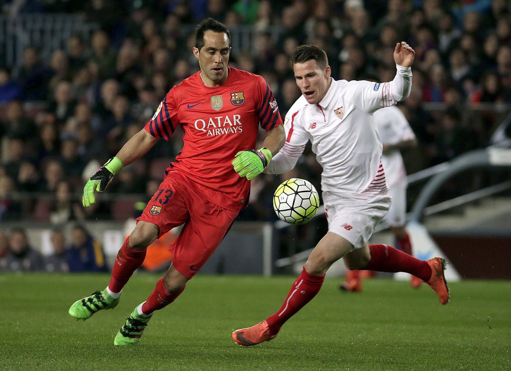 epa05185604 FC Barcelona's Chilean goalkeeper Claudio Bravo (L) duels for then ball with Sevilla FC's French Kevin Gameiro (R) during the Spanish Liga Primera Division soccer match played at Camp Nou stadium in Barcelona, Spain, 28 February 2016. EPA/Alberto Estevez