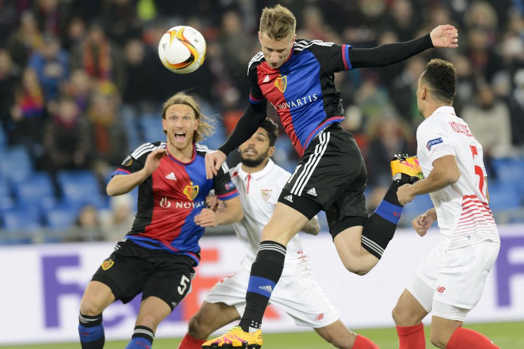From left, Basel's Michael Lang, Sevilla's Benoit Tremoulinas, Basel's Marc Janko and Sevilla's Timothee Kolodziejczak fight for the ball during the UEFA Europa League Round of 16 first leg soccer match between Switzerland's FC Basel 1893 and Spain's Sevilla Futbol Club at the St. Jakob-Park stadium in Basel, Switzerland, on Thursday, March 10, 2016. (KEYSTONE/Laurent Gillieron)