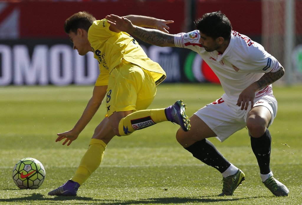 epa05209601 Sevilla's Argentinian midfielder Ever Banega (R) fights for the ball with Villarreal's midfielder Denis Suarez during their Spanish Primera Division soccer match at Sanchez Pizjuan stadium in Sevilla, Spain, 13 March 2016. EPA/Julio Munoz