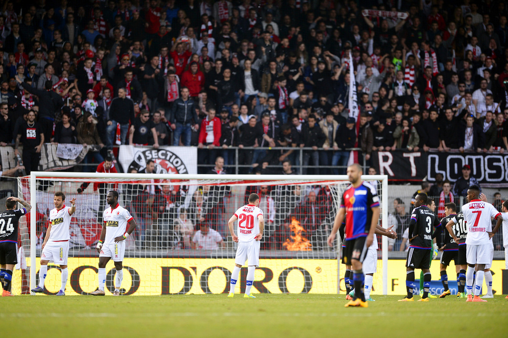 L'arbritre Nikolaj Haenni a interrompu le match suite aux jets d'objet, ici des objets brulants jetes par les supporters, lors de la rencontre de footbal de Super League entre le FC Sion et le FC Bale ce dimanche 20 mars 2016 au stade de Tourbillon a Sion. (KEYSTONE/Olivier Maire)