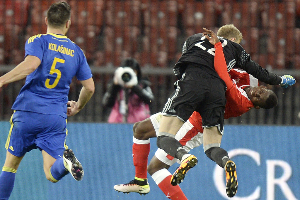 CORRECTS NAME OF GOALKEEPER --- Swiss Breel Embolo, right, and Bosnia Herzegovina's goalkeeper Jasmin Buric, center, collide during the friendly soccer match between Switzerland and Bosnia Herzegovina at the Letzigrund Stadium in Zurich, Switzerland, Tuesday, March 29, 2016. (KEYSTONE/Walter Bieri)