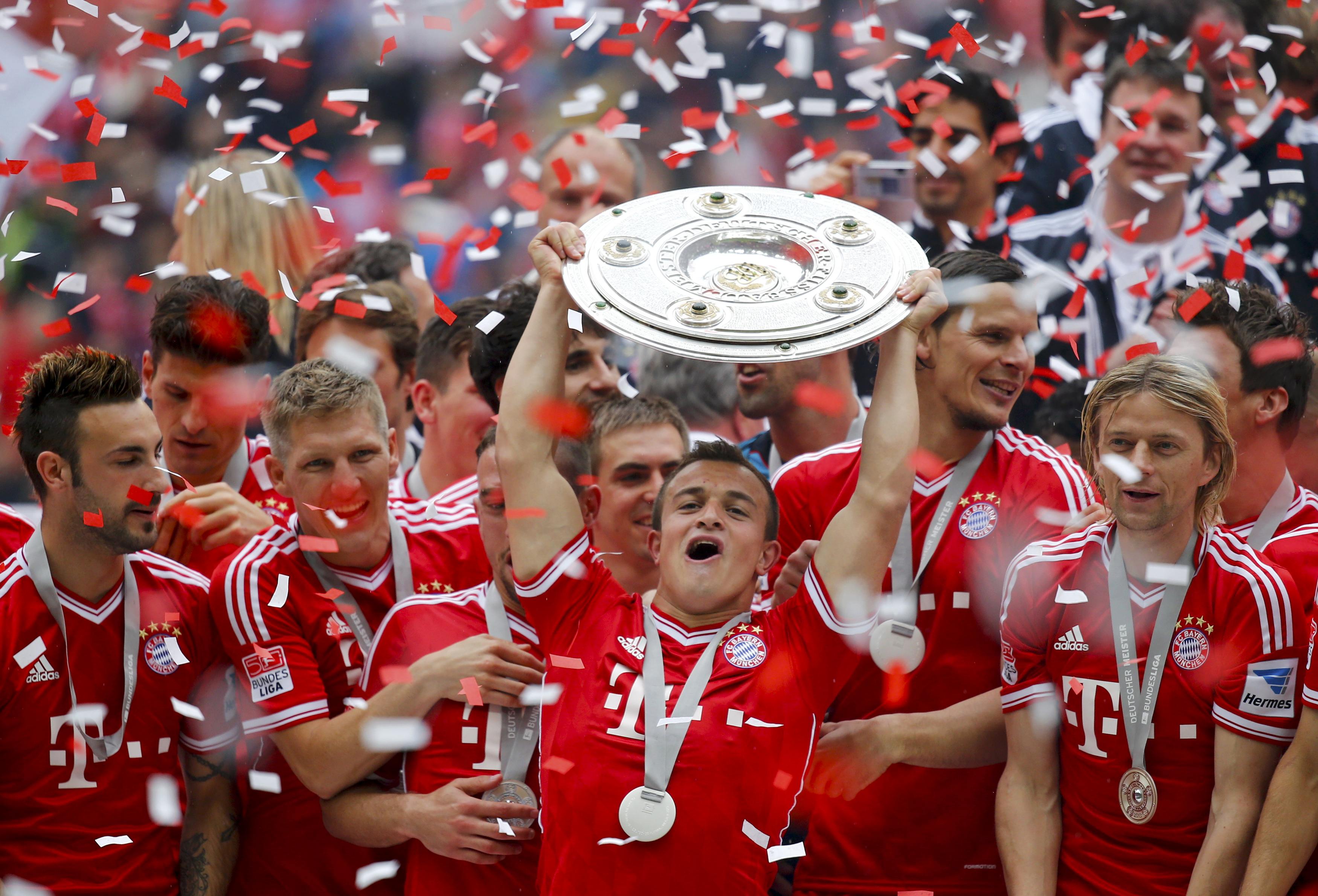 Bayern Munich's Xherdan Shaqiri lifts up the trophy as the team celebrates after their German first division Bundesliga soccer match against Augsburg in Munich, May 11, 2013. Bayern held their 23rd German league title on Saturday after a comfortable 3-0 o