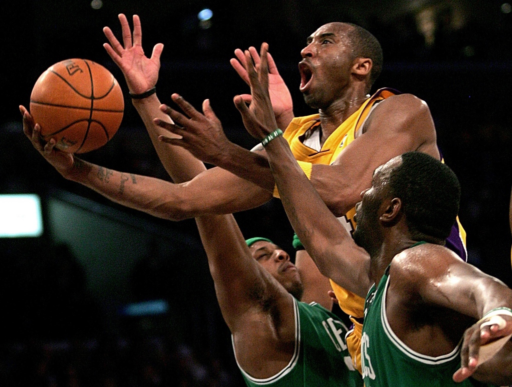 FILE - In this Feb. 23, 2007 file photo, Los Angeles Lakers' Kobe Bryant, top, goes up for a shot between the Boston Celtics' Paul Pierce, left, and Al Jefferson during the first half of an NBA basketball game in Los Angeles. After two decades spent dazzling the world, Bryant will end his basketball career at home with the Los Angeles Lakers on Wednesday night, April 13, 2016.(AP Photo/Branimir Kvartuc, File)