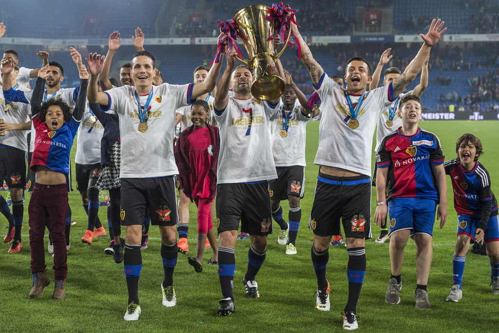 Die zuruecktretenden Spieler Behrang Safari, Walter Samuel und Philipp Degen, von rechts nach links, stemmen den Pokal des Schweizer Fussballmeisters nach dem Fussball Meisterschaftsspiel der Super League zwischen dem FC Basel 1893 und dem Grasshopper Club Zuerich, im Stadion St. Jakob-Park in Basel, am Mittwoch, 25. Mai 2016. (KEYSTONE/Georgios Kefalas)