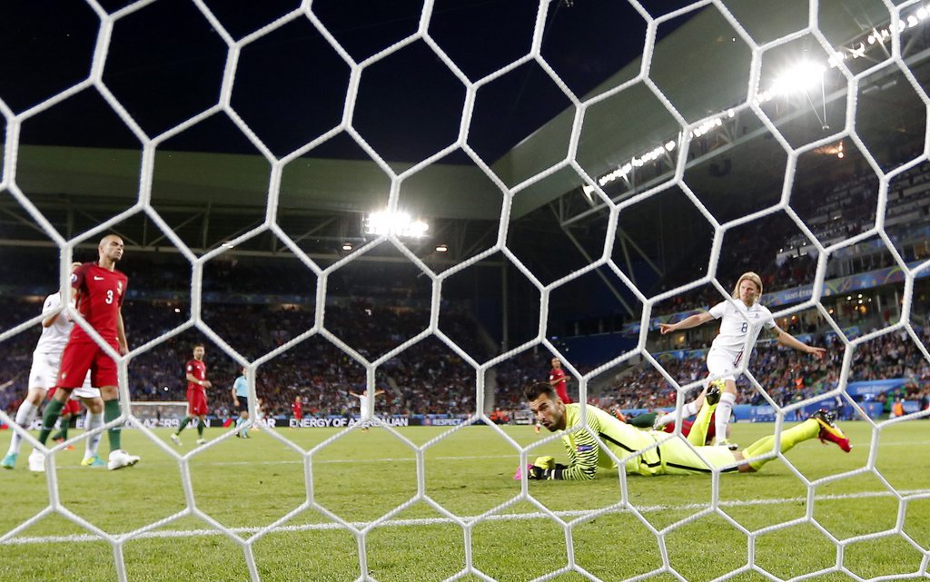 epa05365437 Birkir Bjarnason (R) of Iceland celebrates after beating goalkeeper Rui Patricio of Portugal to score the 1-1 during the UEFA EURO 2016 group F preliminary round match between Portugal and Iceland at Stade Geoffroy Guichard in Saint-Etienne, France, 14 June 2016.....(RESTRICTIONS APPLY: For editorial news reporting purposes only. Not used for commercial or marketing purposes without prior written approval of UEFA. Images must appear as still images and must not emulate match action video footage. Photographs published in online publications (whether via the Internet or otherwise) shall have an interval of at least 20 seconds between the posting.) EPA/CJ GUNTHER EDITORIAL USE ONLY