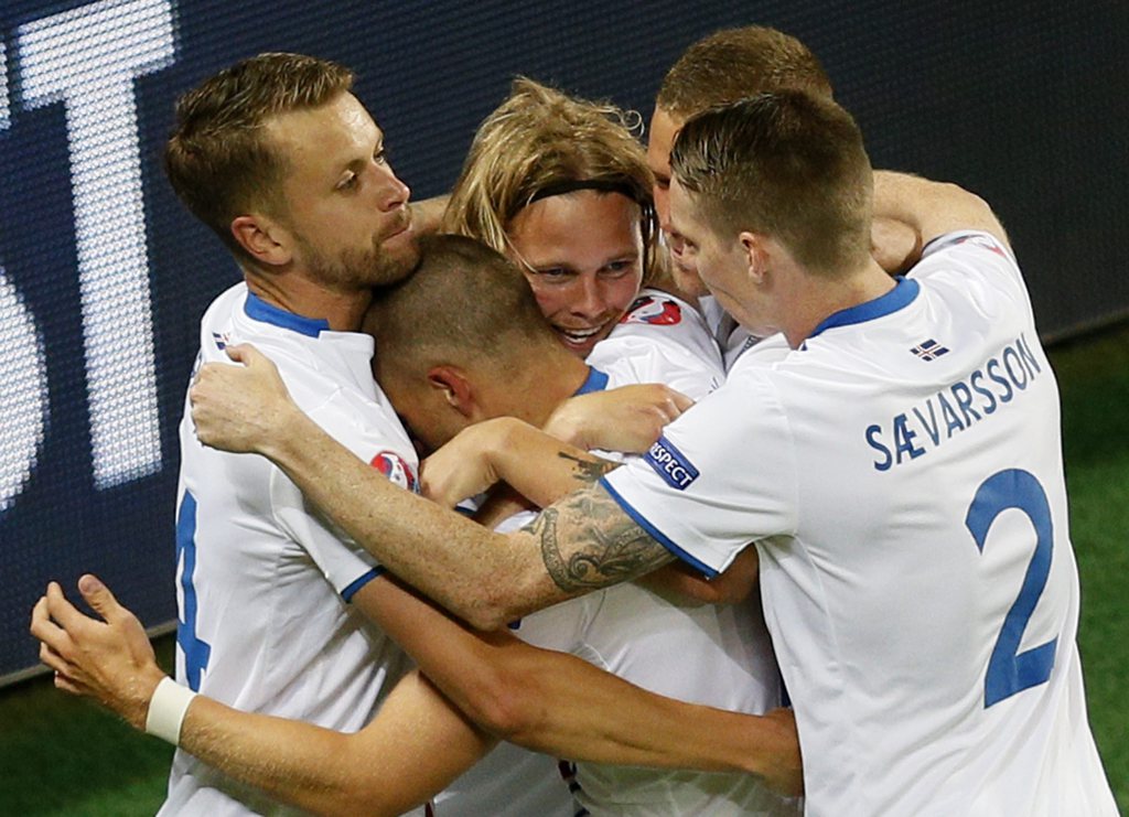 epa05365469 Iceland players celebrate after Birkir Bjarnason (C) scored the 1-1 goal during the UEFA EURO 2016 group F preliminary round match between Portugal and Iceland at Stade Geoffroy Guichard in Saint-Etienne, France, 14 June 2016.....(RESTRICTIONS APPLY: For editorial news reporting purposes only. Not used for commercial or marketing purposes without prior written approval of UEFA. Images must appear as still images and must not emulate match action video footage. Photographs published in online publications (whether via the Internet or otherwise) shall have an interval of at least 20 seconds between the posting.) EPA/SERGEY DOLZHENKO EDITORIAL USE ONLY