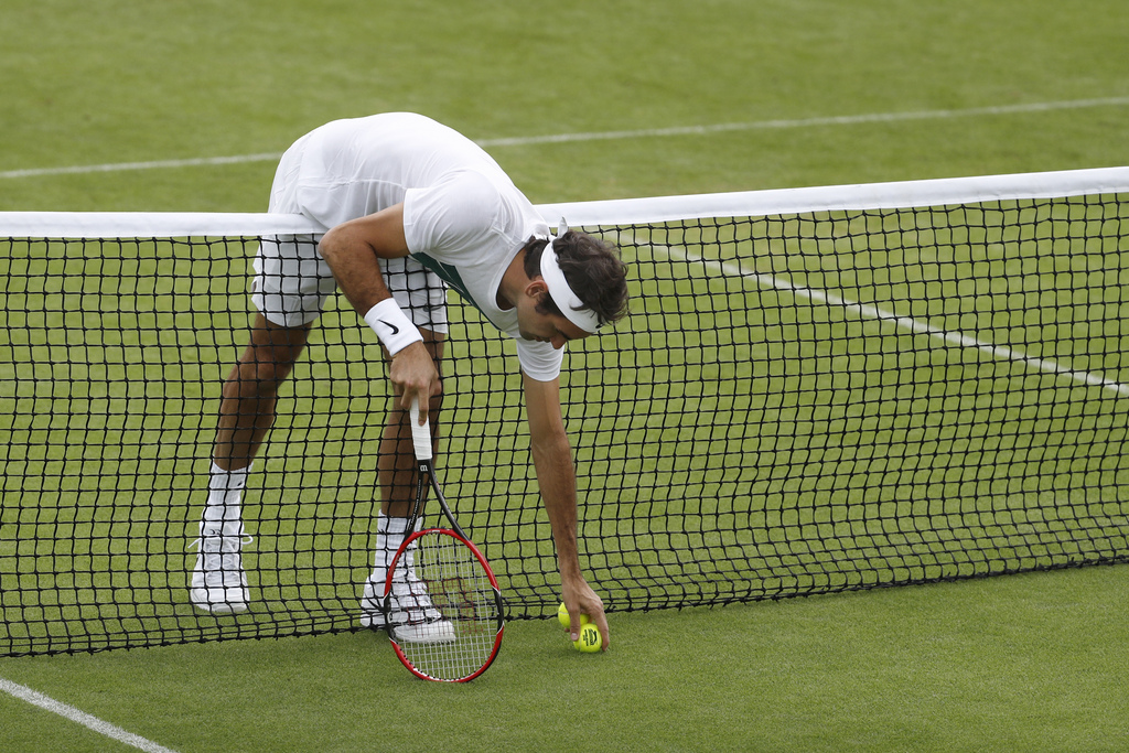 Roger Federer of Switzerland picks up a ball during a training session at the All England Lawn Tennis Championships in Wimbledon, London, Sunday, June 26, 2016. The Wimbledon Tennis Championships 2016 will be held in London from 27 June to 10 July. (KEYSTONE/Peter Klaunzer)