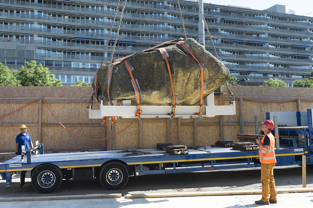 Ein 25 bis 30 Tonnen schwerer Findling wird als Grundstein zum Baubeginn der Sanierung der St. Jakobshalle aufgestellt, in Basel, am Freitag, 8. Juli 2016. Die kuenstlerische Intervention des Findlings, der unter einer tragenden Saeule steht und nicht mehr umplatziert werden kann, stammt vom Kuenstler Eric Hattan. Der Abschluss aller Sanierungs- und Umbauarbeiten ist fuer Ende 2018 geplant. (KEYSTONE/Georgios Kefalas).