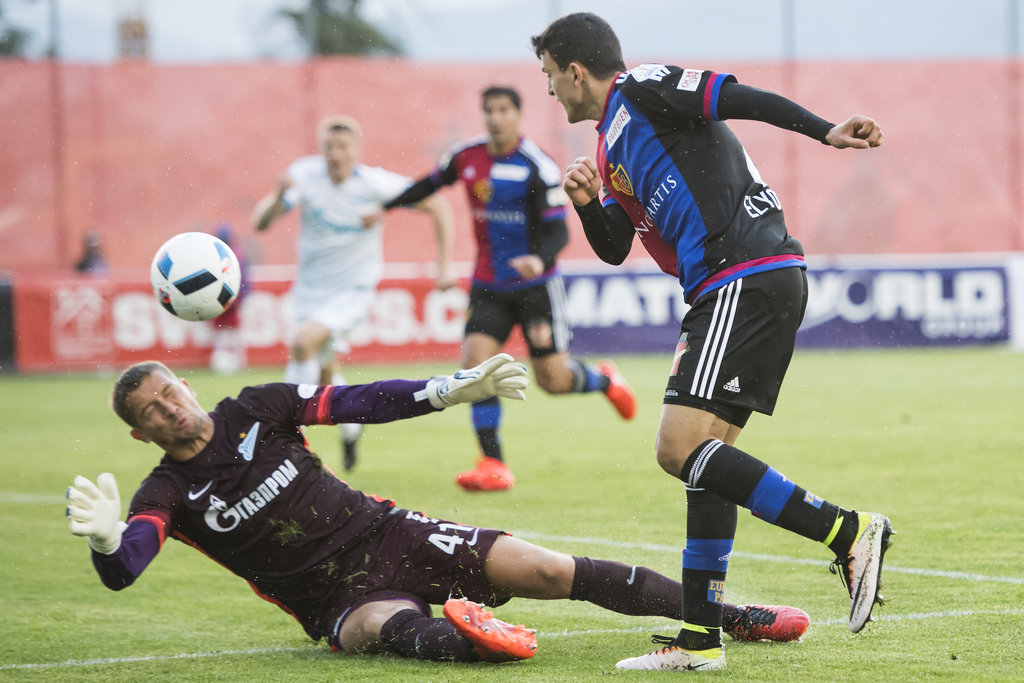 Le gardien russe Mikhail Kerzhakov, gauche, lutte pour le ballon avec le joueur balois Mohamed Elyounoussi, droite, lors de la rencontre entre le FC Basel et Zenith St-Petersbourg a l'occasion du 