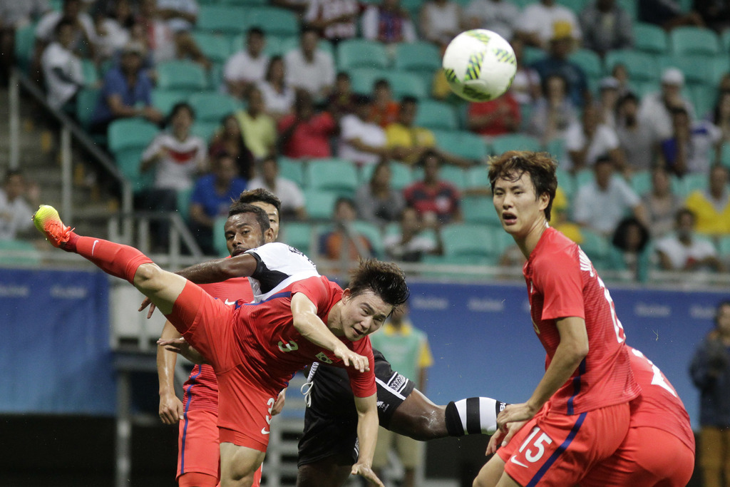 Korea's Lee Seulchan, center, jumps for the ball during a group C match of the men's Olympic football tournament between Fiji and Korea at the Fonte Nova Arena in Salvador, Brazil, Thursday, Aug. 4, 2016. Korea won 8-0. (AP Photo/Arisson Marinho)