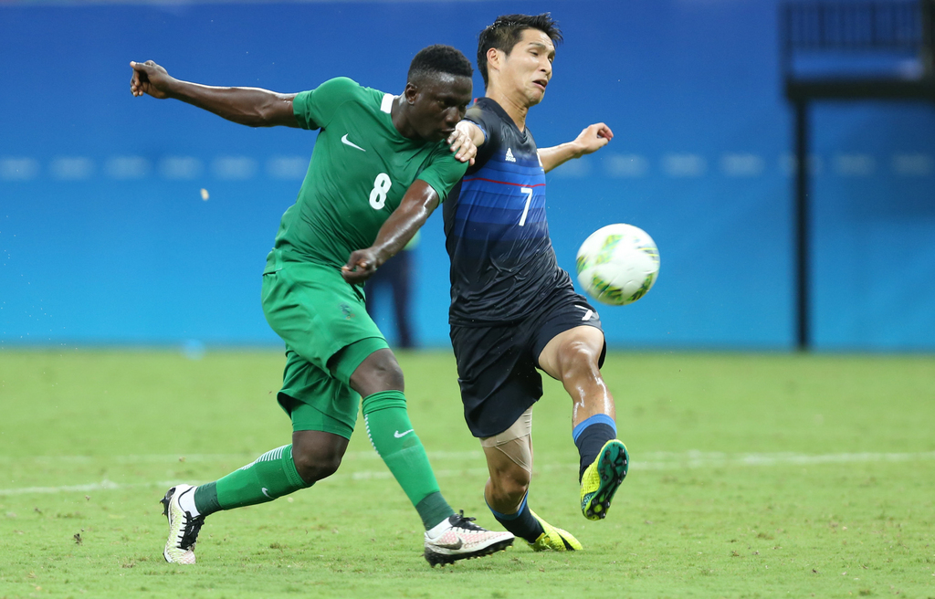 Nigeria's Oghenekaro Etebo strikes the ball to score as Japan's Riki Harakawa fails to stop him during a group B match of the men's Olympic football tournament between Japan and Nigeria at the Amazonia Arena, in Manaus, Brazil, Thursday, Aug. 4, 2016. (AP Photo/Michael Dantas)