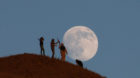 Free Syrian army fighters stand atop of a hill as the moon is seen in the background in the south of Nawa city, in Deraa Gove