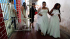 A woman in a wedding gown walks to a mass wedding ceremony, held 17 male inmates, in the Carcel Villa Hermosa prison in Cali,