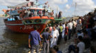 People gather along the shore of the Mediterranean Sea during a search for victims after a migrant boat capsized, in Al-Behei