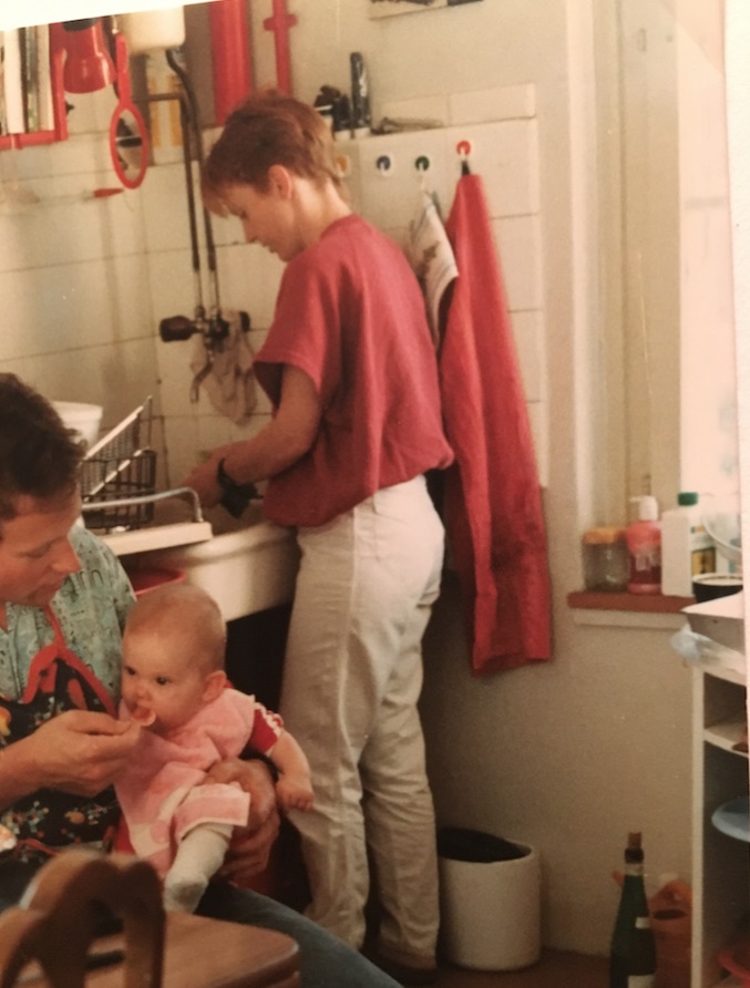 Damals eher an Brei als an Hose interessiert: Die Autorin beim Mittagessen mit Mom Jeans-Mami im Hintergrund.