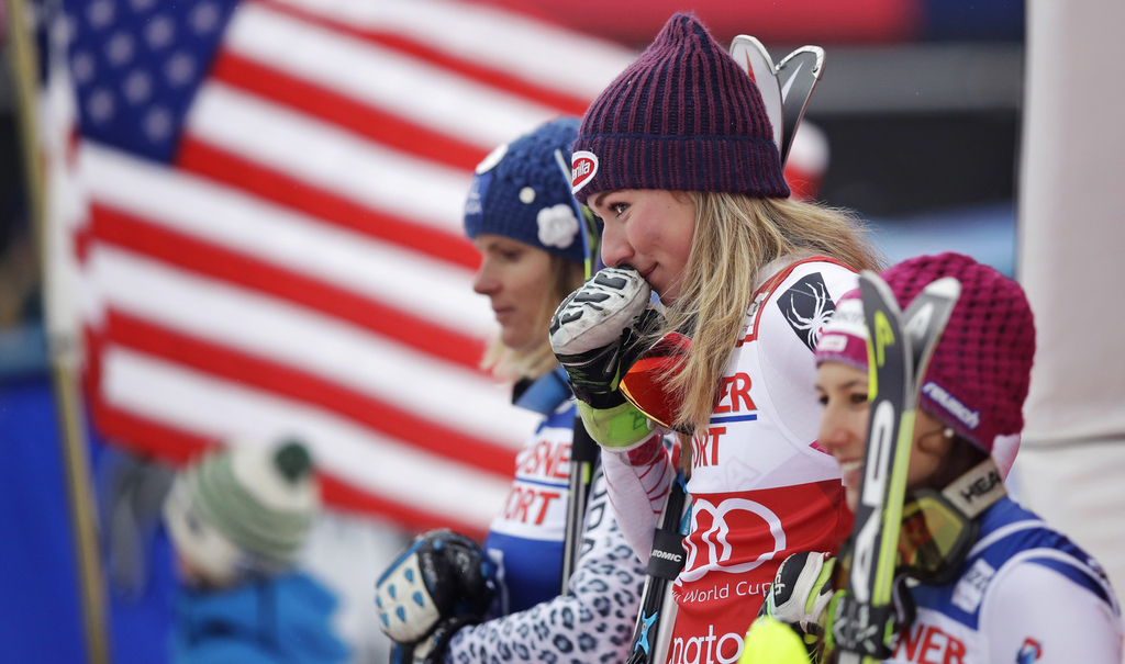 Mikaela Shiffrin, of the United States, holds her glove to her face and smiles towards her grandmother while standing on the podium after winning the alpine skiing women's World Cup slalom in Killington, Vt., Sunday, Nov. 27, 2016. (AP Photo/Charles Krupa)