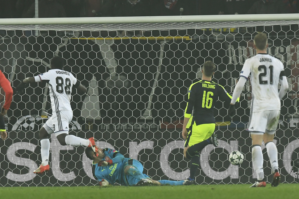 Basel's Seydou Doumbia, left, scores the first goal for Basel against Arsenal's goalkeeper David Ospina, right, during an UEFA Champions League Group stage Group A matchday 6 soccer match between Switzerland's FC Basel 1893 and England's Arsenal FC in the St. Jakob-Park stadium in Basel, Switzerland, on Tuesday, December 6, 2016. (KEYSTONE/Walter Bieri)
