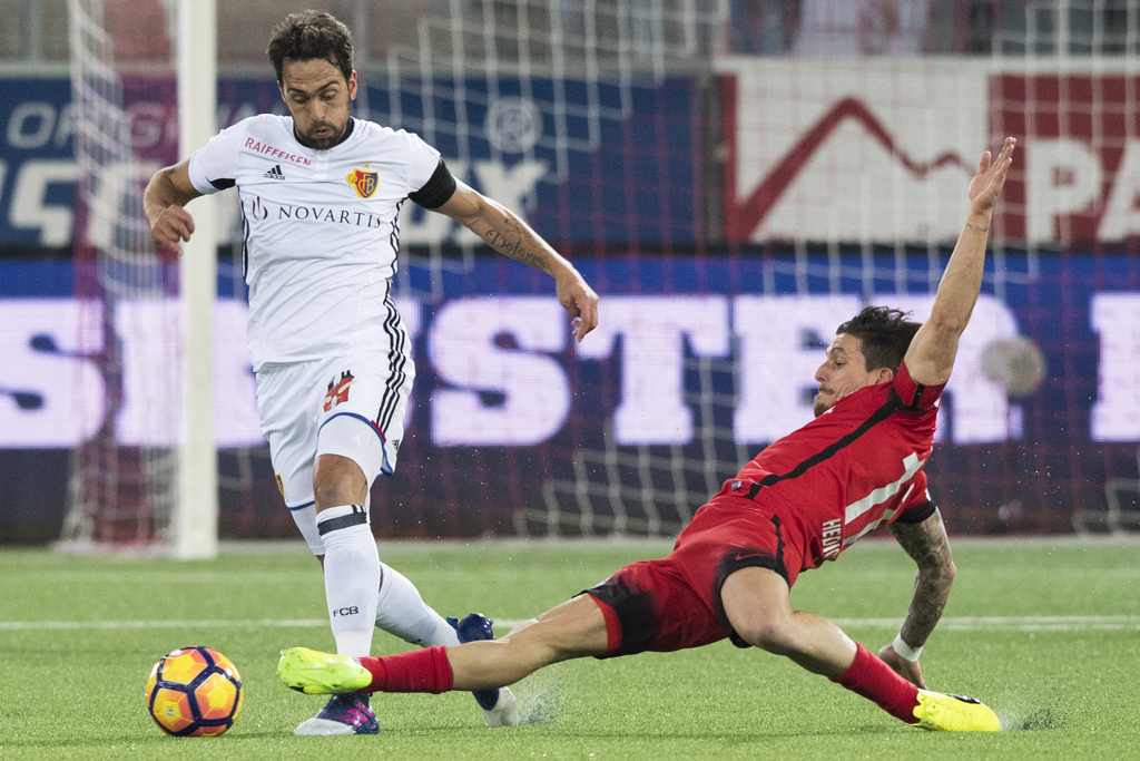 Basels Matias Delgado, links, im Spiel gegen Thuns Dennis Hediger, rechts, im Fussball Meisterschaftsspiel der Super League zwischen dem FC Thun und dem FC Basel, am Samstag, 11. Februar 2017, in der Stockhorn Arena in Thun. (KEYSTONE/Anthony Anex)