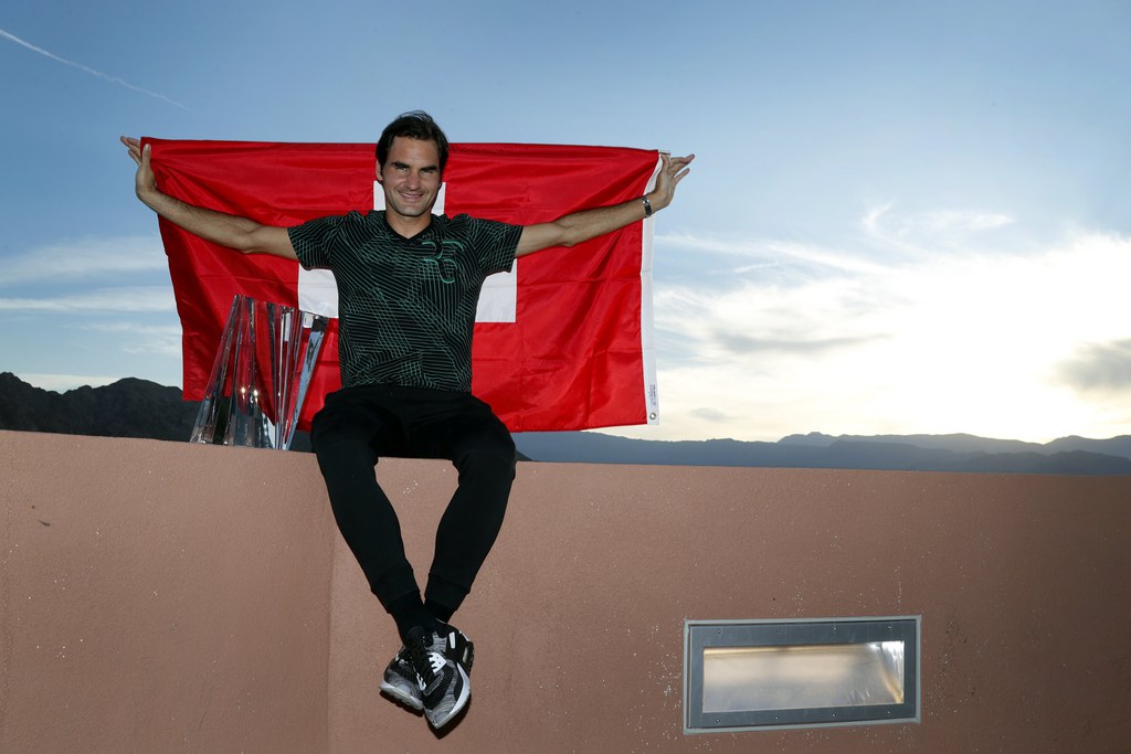 epa05859093 Roger Federer of Switzerland poses with the trophy and the Swiss national flag after defeating Stan Wawrinka of Switzerland in the men's final match at the 2017 BNP Paribas Open tennis tournament at the Indian Wells Tennis Garden in Indian Wells, California, USA, 19 March 2017. EPA/PAUL BUCK