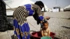 A displaced boy is being washed by a relative at Hammam al-Alil camp south of Mosul, Iraq May 10, 2017.  REUTERS/Suhaib Salem