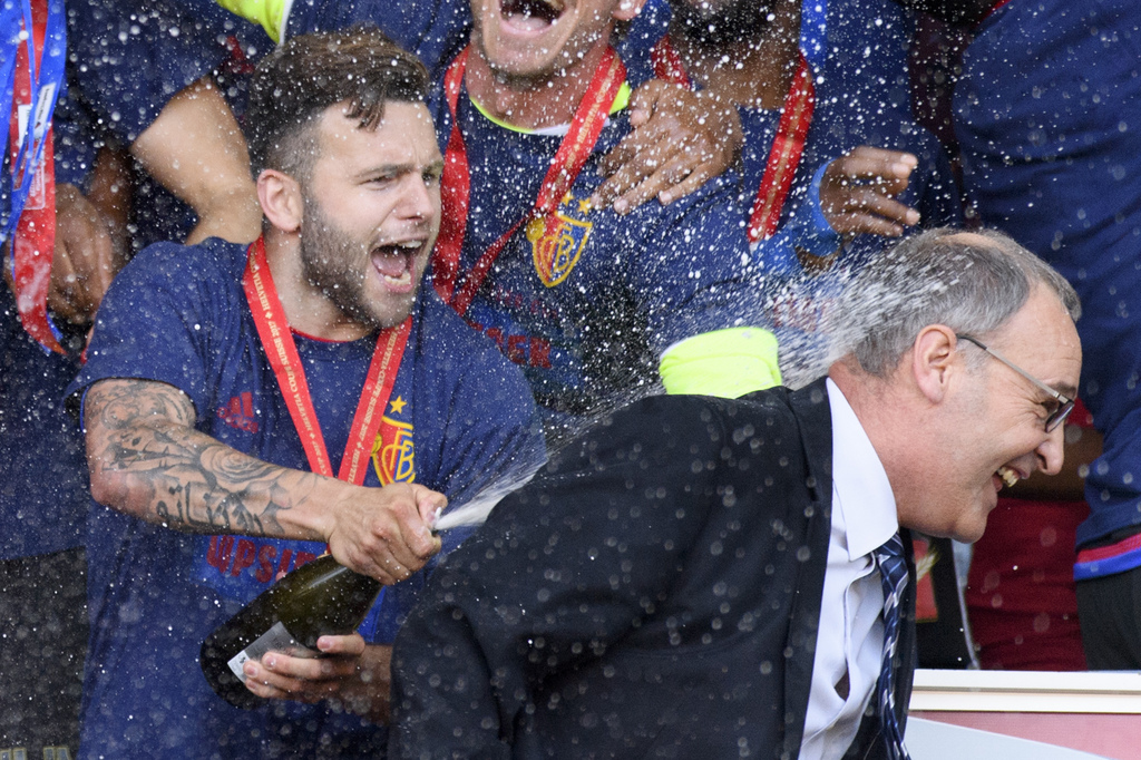 Basel's midfielder Renato Steffen, left, sprays with champagne Federal councillor Guy Parmelin, right, as Basel's players celebrate with the trophy after winning the the Swiss Cup final soccer match between FC Basel 1893 and FC Sion at the stade de Geneve stadium, in Geneva, Switzerland, Thursday, May 25, 2017. (KEYSTONE/Laurent Gillieron)
