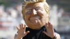 A protester wears a mask depicting U.S. President Donald Trump during a demonstration against a G7 summit organised by Oxfam 