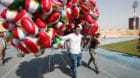 A man carries balloons decorated with Kurdistan flags before the start of a rally calling to vote yes in the coming referendu