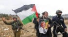 A Palestinian protester (C) holds a poster depicting former South African President Nelson Mandela during a demonstration aga