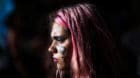 A woman has the symbol for women painted on her face during a demonstration on International Women's Day in Buenos Aires, Arg