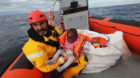 Oscar Camps, founder of Spanish NGO Proactiva Open Arms, holds a migrant child inside a rescue craft after pulling it from an