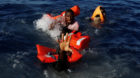 Migrants try to stay afloat after falling off their rubber dinghy during a rescue operation by the Malta-based NGO Migrant Of