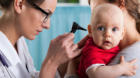 Child's otolaryngologist doing ear examination of infant